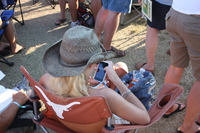 A girl playing games on her iPhone at Blues Traveler